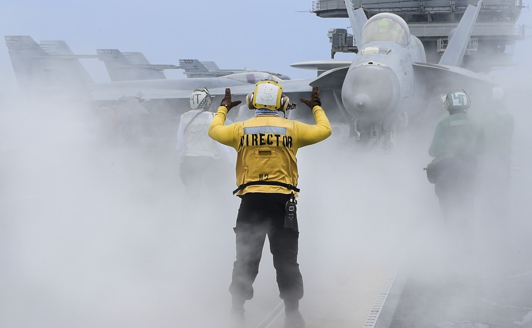 Aviation Boatswain’s Mate (Handling) Airman Thomas McLaughlin directs an F/A-18E Super Hornet on May 26, 2020, on the flight deck of the aircraft carrier USS Ronald Reagan (CVN 76) in the Philippine Sea. (MC3 Erica Bechard/Navy)