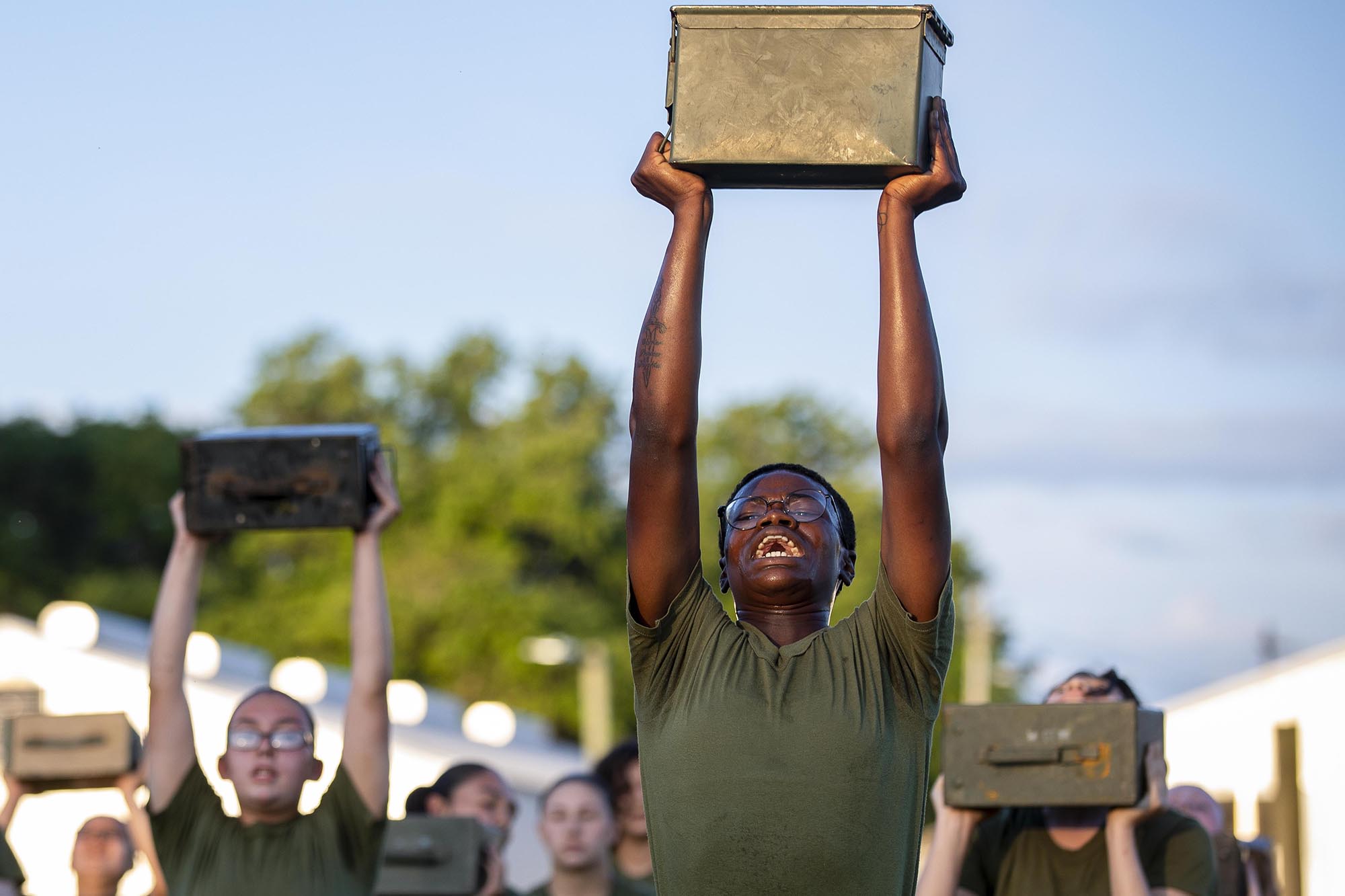 Recruits with Papa Company, 4th Recruit Training Battalion, execute ammo can lifts during physical training on Marine Corps Recruit Depot Parris Island, S.C., May 11, 2021. (Sgt. Dana Beesley/Marine Corps)