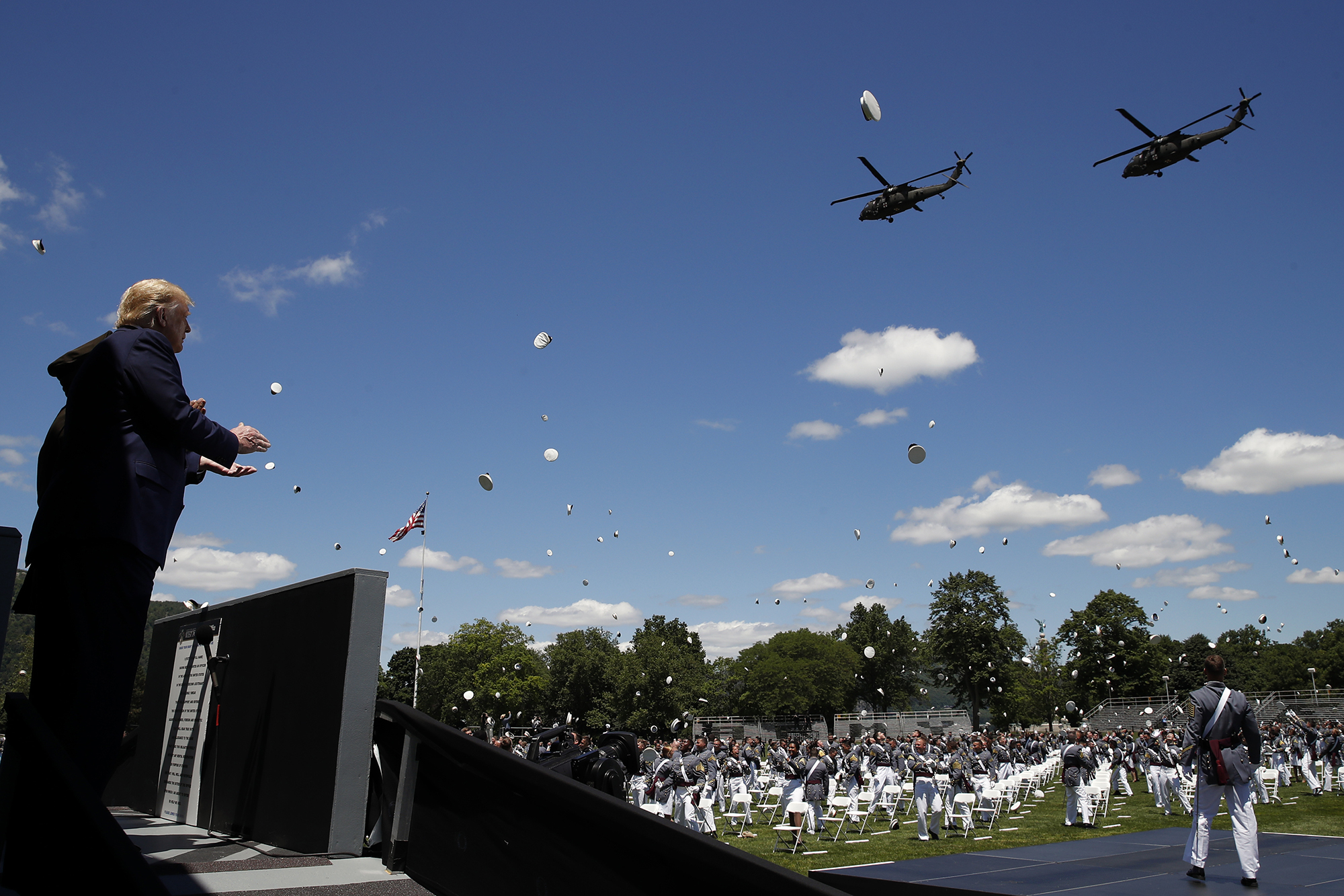 President Donald Trump applauds as Army helicopters fly over and West Point cadets toss their caps into the air at the end of commencement ceremonies on the parade field, at the United States Military Academy in West Point, N.Y., Saturday, June 13, 2020. (Alex Brandon/AP)