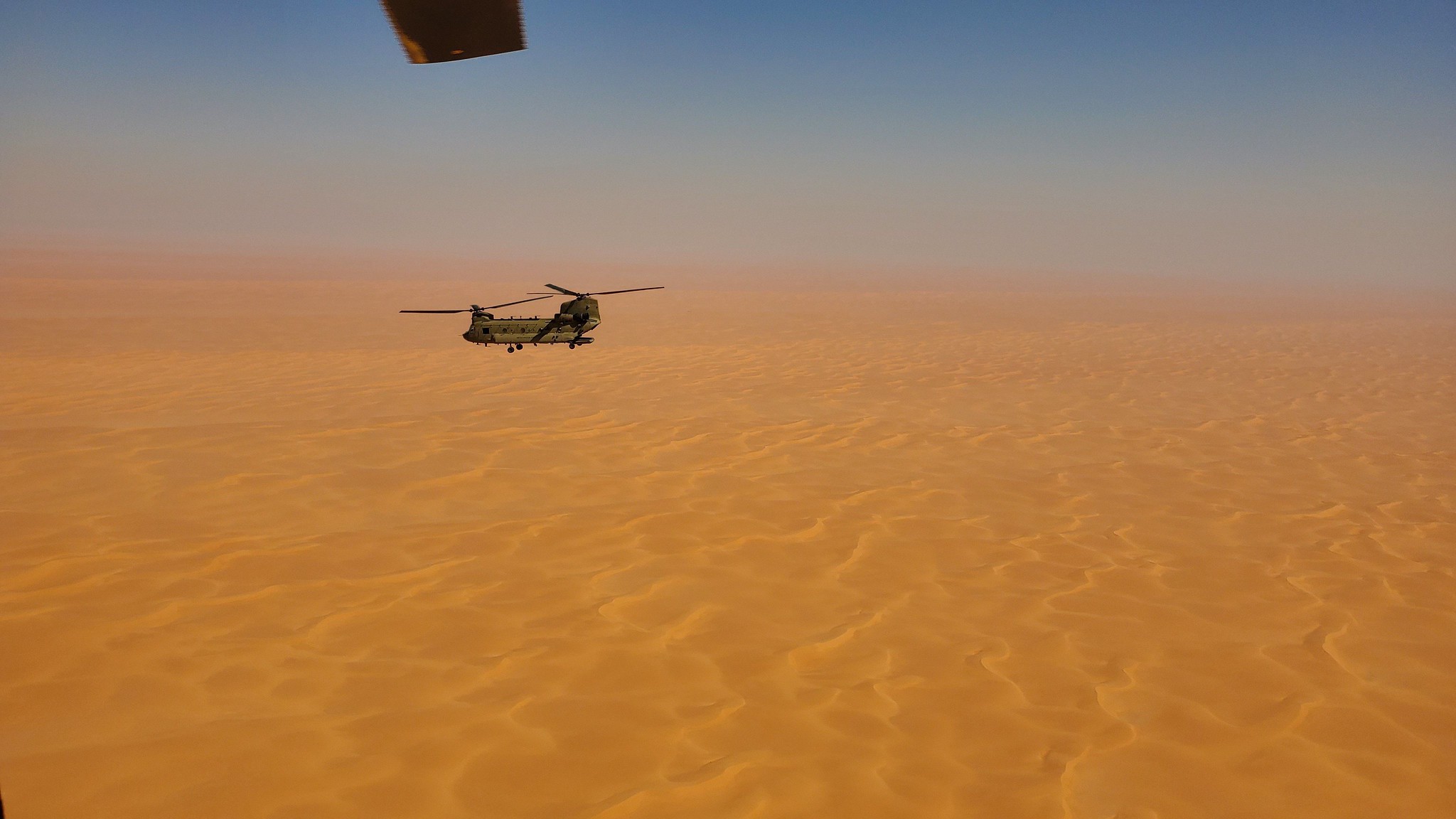 A CH-47 Chinook helicopter, operated by soldiers with Bravo Company, 3-238th General Support Aviation Battalion, 28th Expeditionary Combat Aviation Brigade, flies over a desert on Oct. 18, 2020, in the 28th ECAB's area of operations in the Middle East. (Spc. Jacob Robinson/Army)