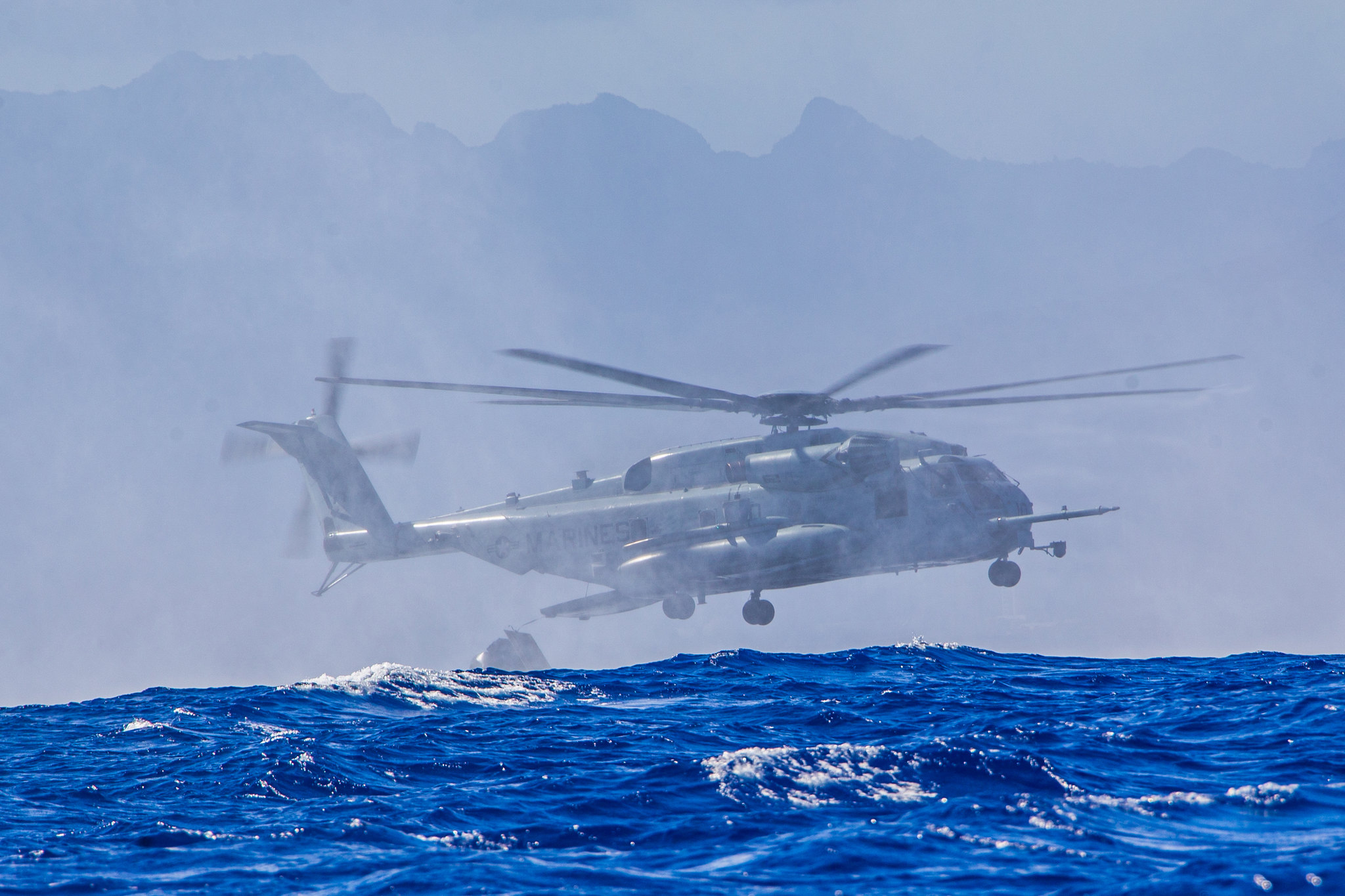 Marines approach the water with a CH-53E Super Stallion helicopter during helicopter casting training with U.S. Navy sailors off the island of Oahu, Hawaii, June 30, 2020. (Lance Cpl. Jacob Wilson/Marine Corps)