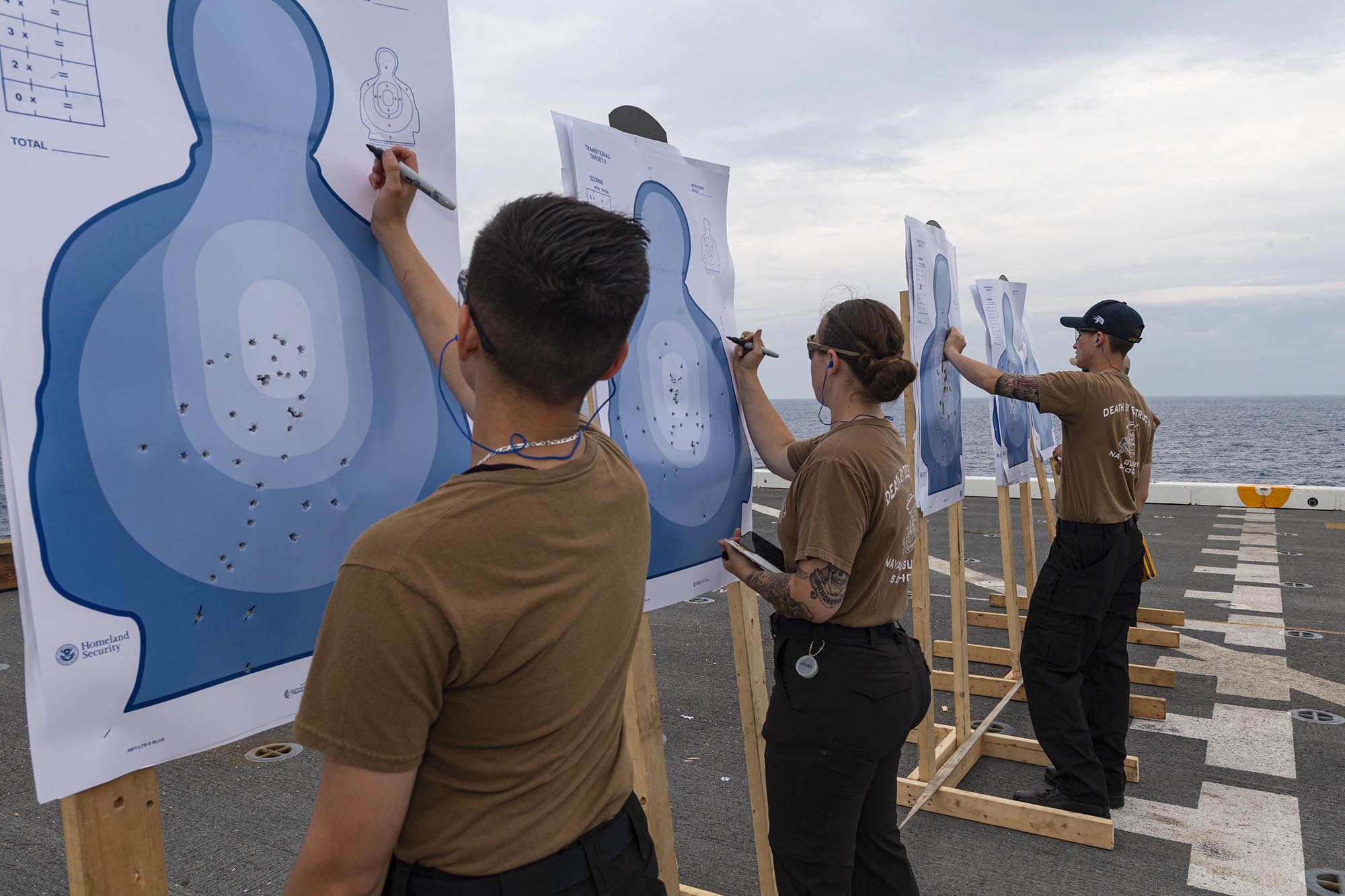 Sailors aboard USS New Orleans (LPD 18) serving as weapons instructors score targets May 30, 2021, following a qualifying gun shoot for sailors assigned to the ship in the East China Sea. (MC2 Desmond Parks/Navy)