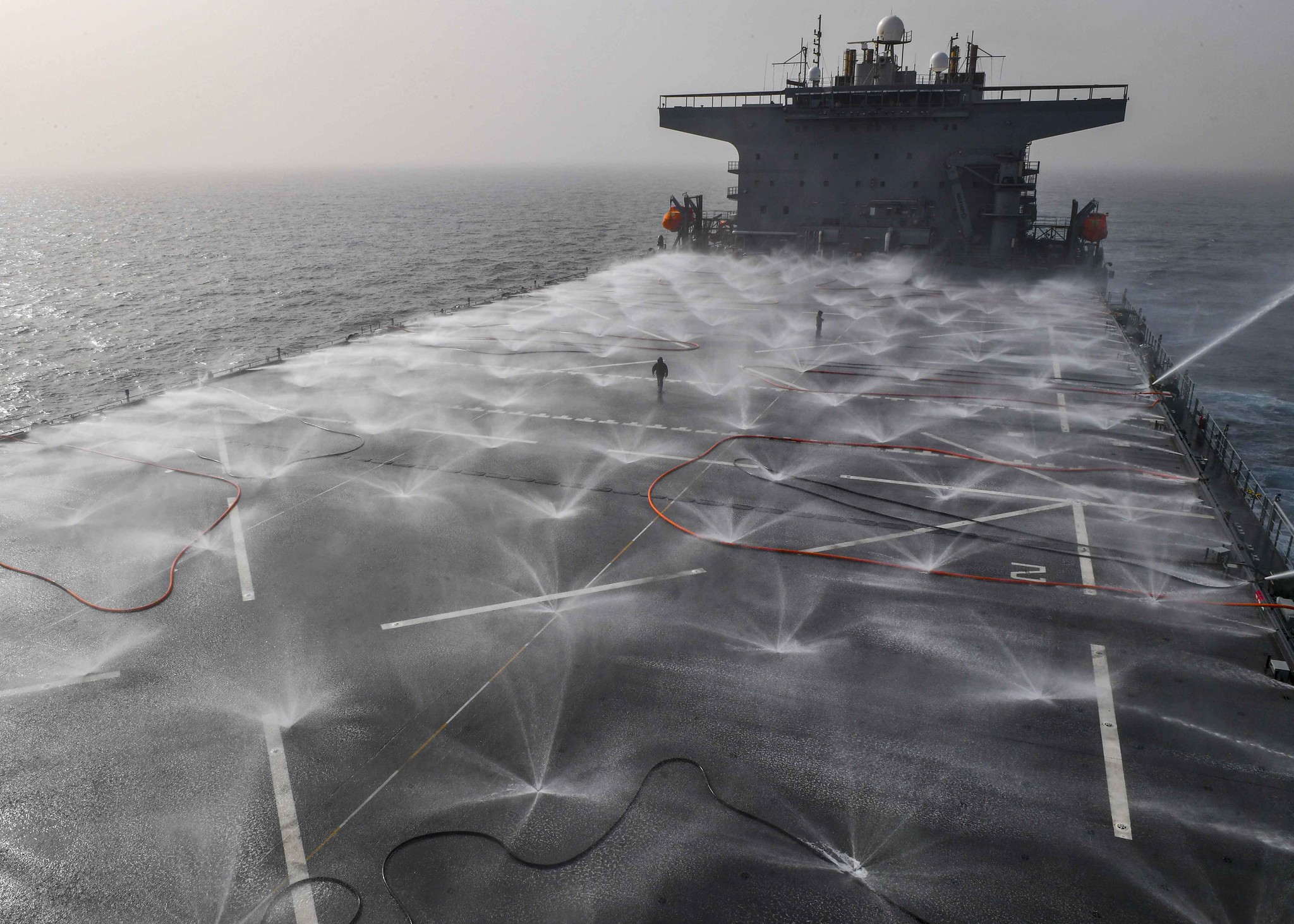 Sailors from the air department check the functionality of the flight deck sprinkler system on board the expeditionary sea base USS Hershel “Woody” Williams (ESB 4) in the Atlantic Ocean, March 13, 2021. (MC2 Eric Coffer/Navy)