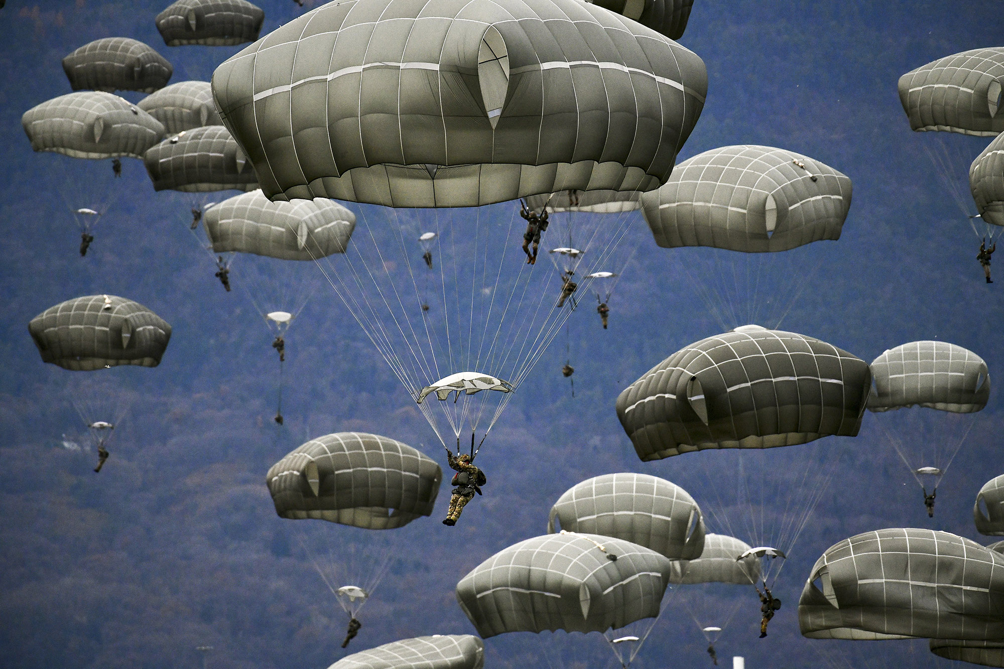 U.S. Army and Italian Army paratroopers conduct airborne operations after exiting a U.S. Air Force C-130 Hercules aircraft at Juliet Drop Zone, Pordenone, Italy, Dec. 10, 2020. (Paolo Bovo/Army)