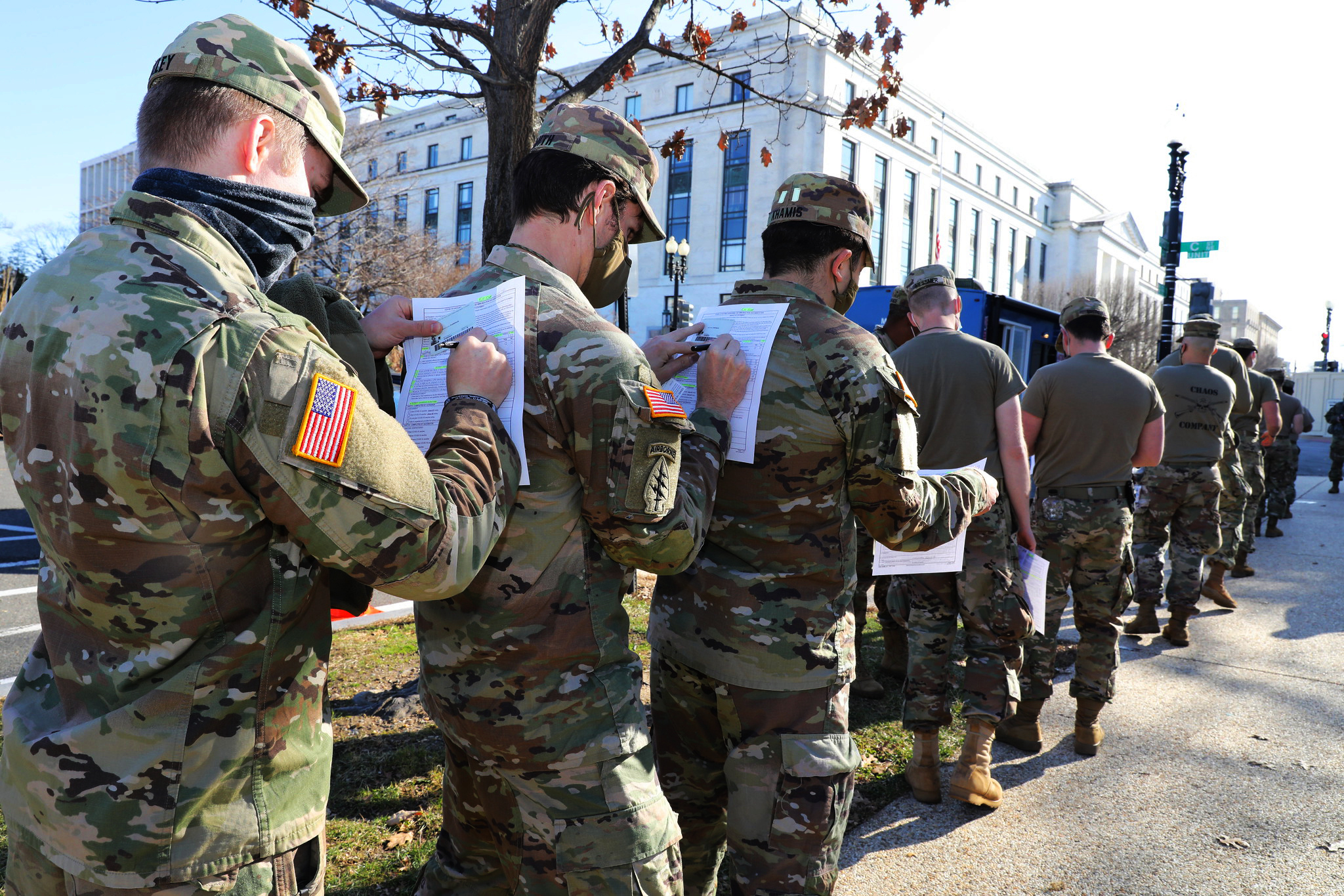 Soldiers in the Maryland Army National Guard use the back of the soldier in front of them to fill out their medical paperwork to receive the COVID-19 vaccine at the U.S. Capitol Complex in Washington on Jan. 14, 2021. (Sgt. Chazz Kibler/National Guard)
