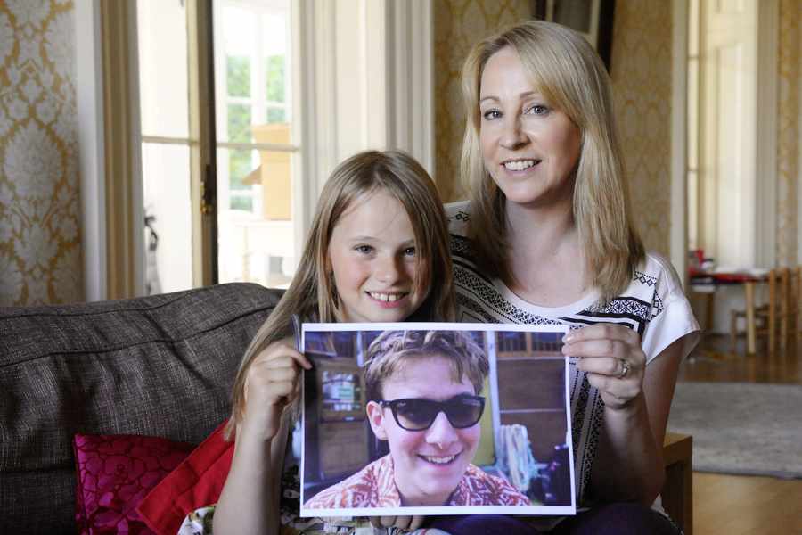 Emma Turner with daughter Fifi (9) holding a picture of her brother Izaak (17). Fifi has been the 'glue' holding the family together since Izaak's injury