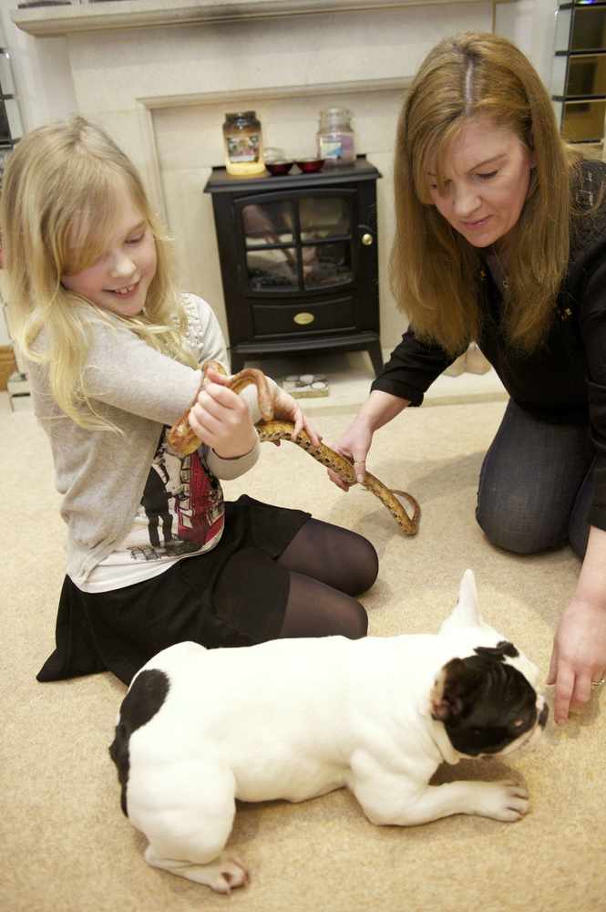 Poppy and her friend Saffy the corn snake with Jasmine Morley (9) and her mum Sharon Morley