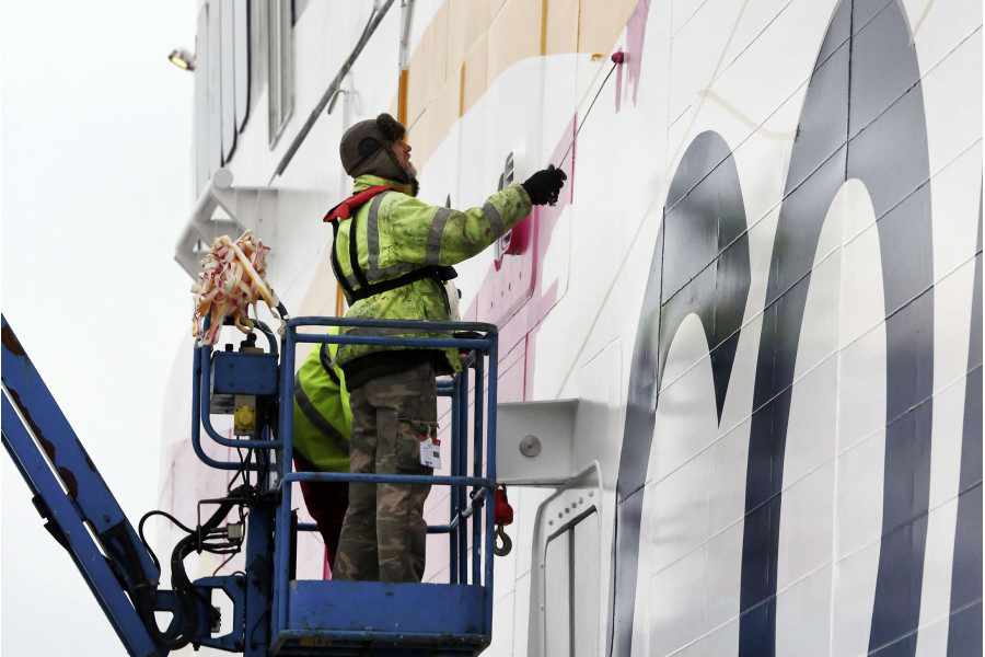Workers paint the livery of the new ship