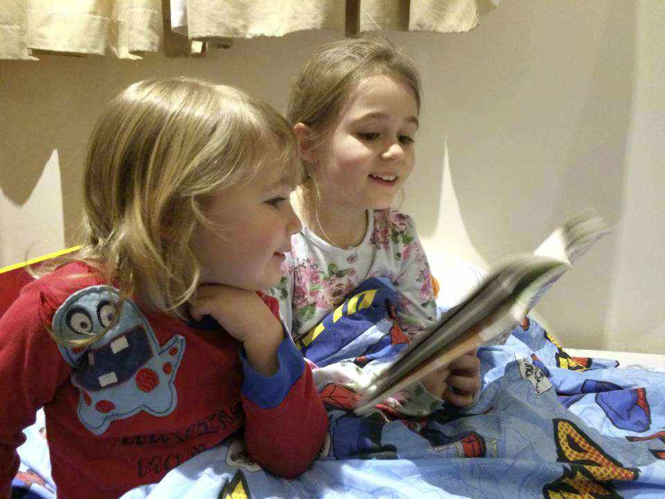 Amelie d'Orleans (7) reads to her brother Winter (2) at bedtime