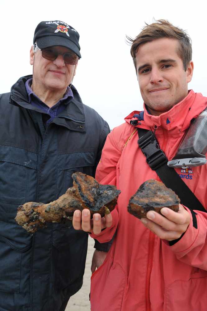 Stuart Elliott (left) with RNLI lifeguard Jake Powell, holding an un-exploded mortar round