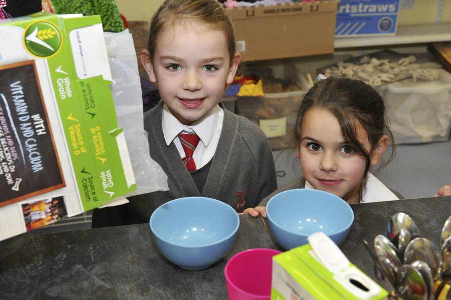 Rise and shine: Eila Burns (6) and Ella Felix (5) tuck into breakfast at St Peter's School