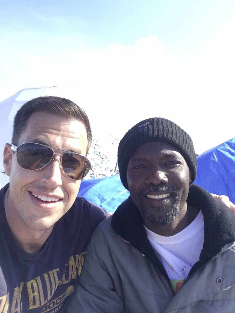 Jersey Calais Refugee Aid Group member Evan Smith meets one of the refugees at the 'Jungle' camp in Calais