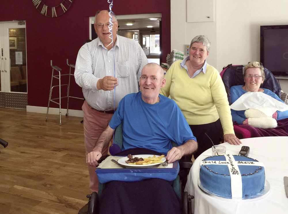 Steve Quinn at the Jersey Cheshire Home with general manager David Lord, care manager Ann Appleton and resident Wendy Renouf – and a farewell cake baked by Adrian Doolan Picture: JERSEY CHESHIRE HOME