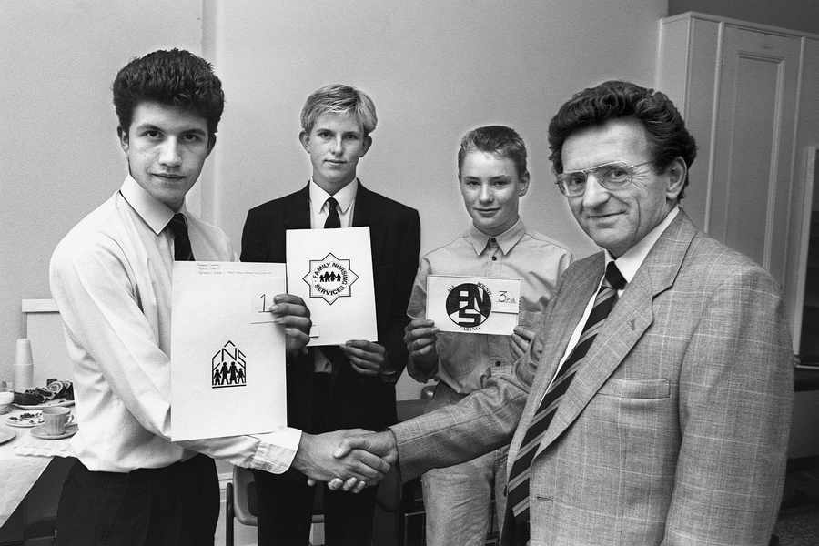 In 1989 a competition was held to find a new Family Nursing and Home Care logo. The charity's then chairman, Leslie Crapp, is seen here congratulating the winners. Victoria College pupil Robert Gregory (17) took first prize, with College pupil Jeremy Le Rossignol (15) taking second prize and third prize went to 15 year old Le Rocquier pupil Brendon Lewis.