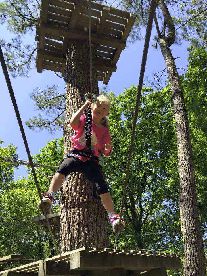 Lucy's niece Kezia swinging through the trees at Adrénaline Parc Moliets