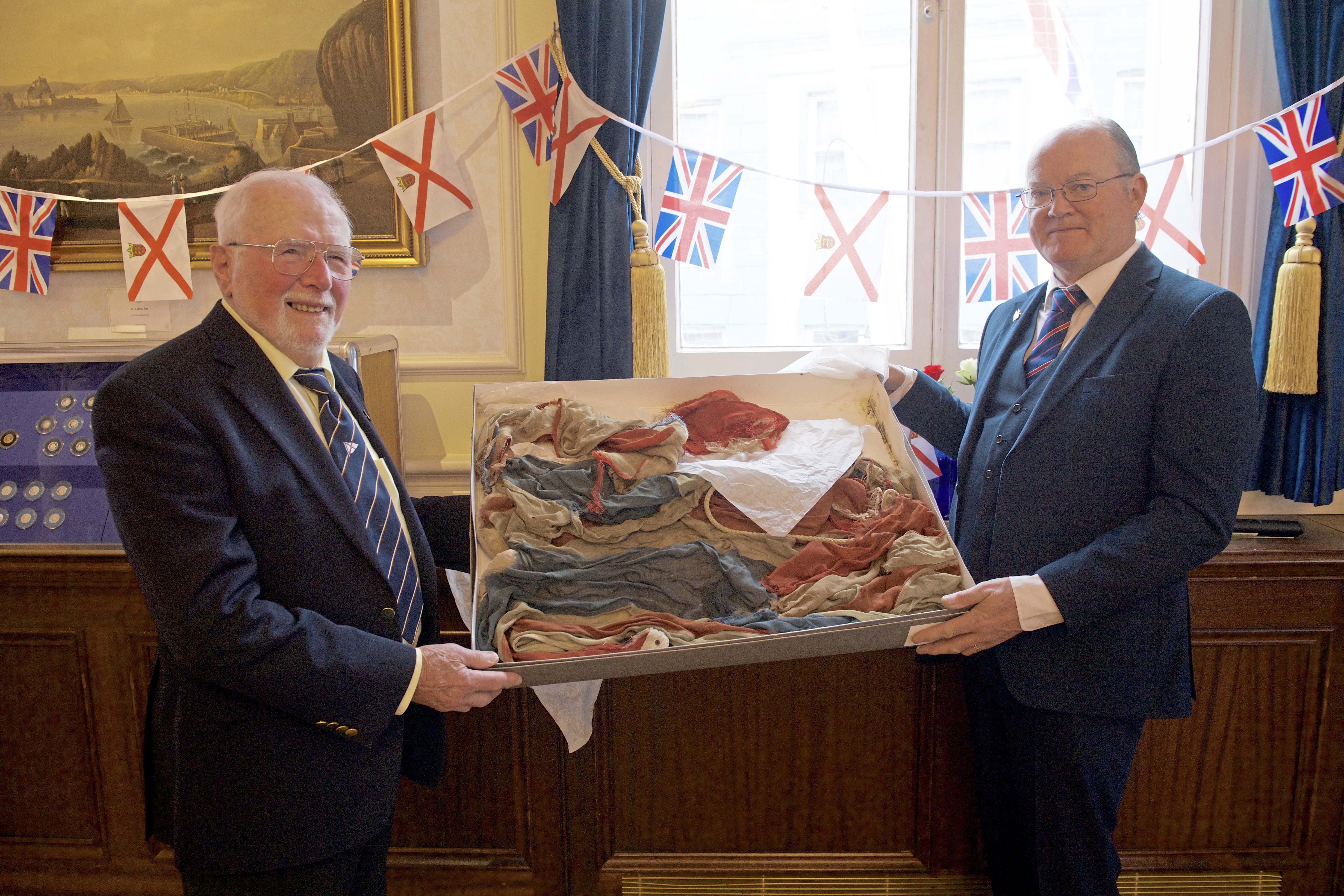 Liberation breakfast at the Town Hall. Leo Harris donates a flag, which was the first Union flag to be flown towards the end of the Occupation, to Constable Simon Crowcroft. Picture: JON GUEGAN. (24622250)