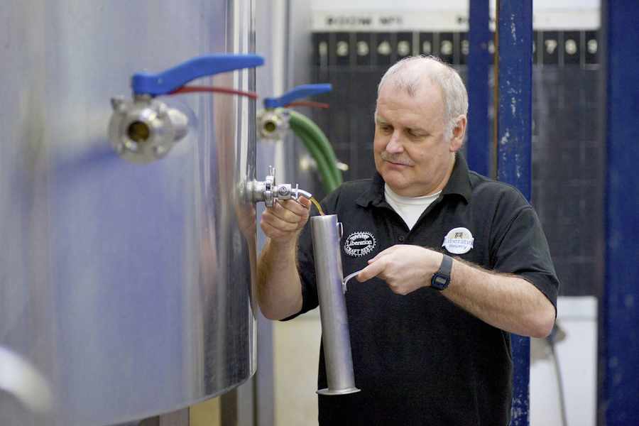 Paul Hurley takes a sample from the fermenting vessel