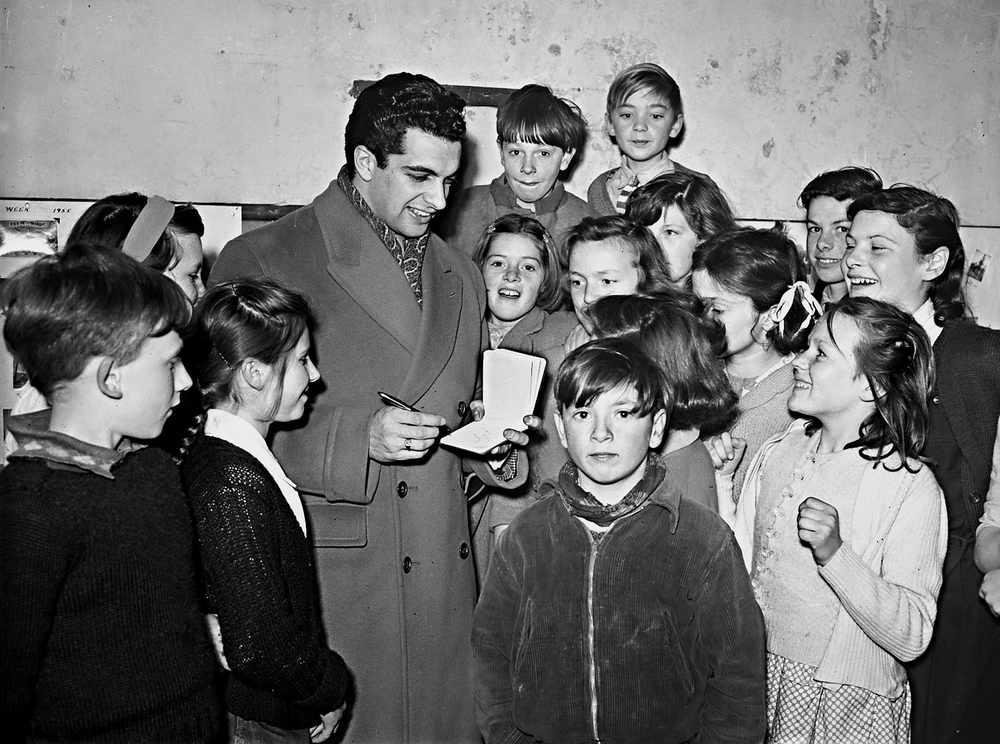 Popular singer and entertainer Frankie Vaughan visited the Island in March of this year and is pictured here signing autographs for fans at St Peter's Barracks Youth Club