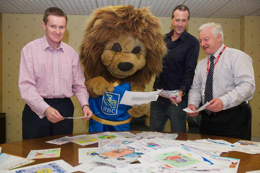 Andy Quinn, chairman of the Swimarathon Organising Committee, Leo the Lion, Brian McKenzie, JEP Studio Manager, and John Le Maistre, president of the Lions Club of Jersey, judging the Swimarathon newsletter cover competition.