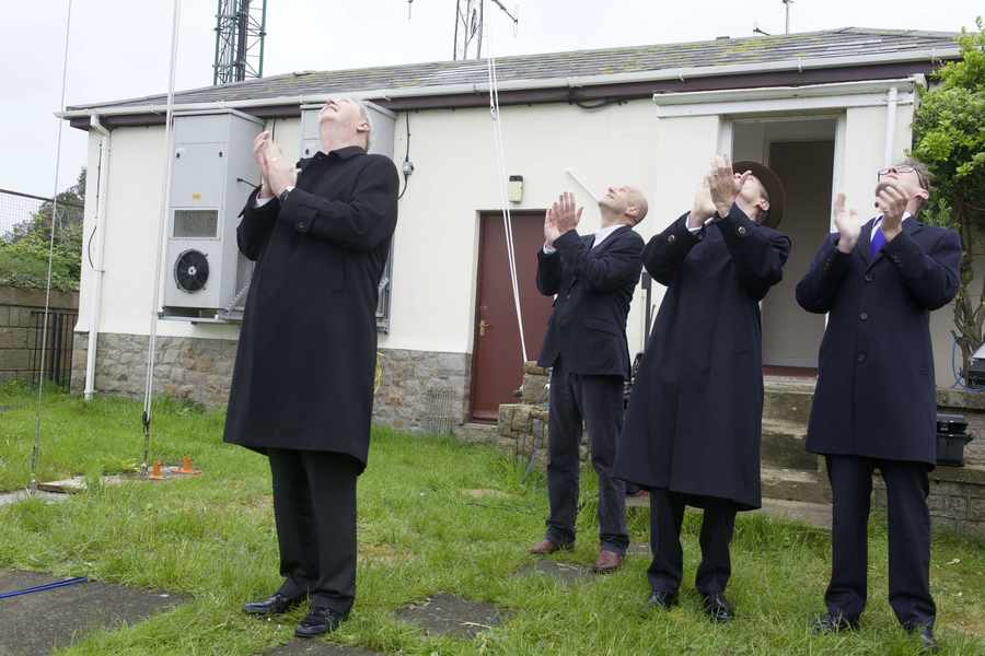 A new Jersey flag is unfurled at Fort Regent signal station watched by Jon Carter, Sir John McColl and Senator Ian Gorst.