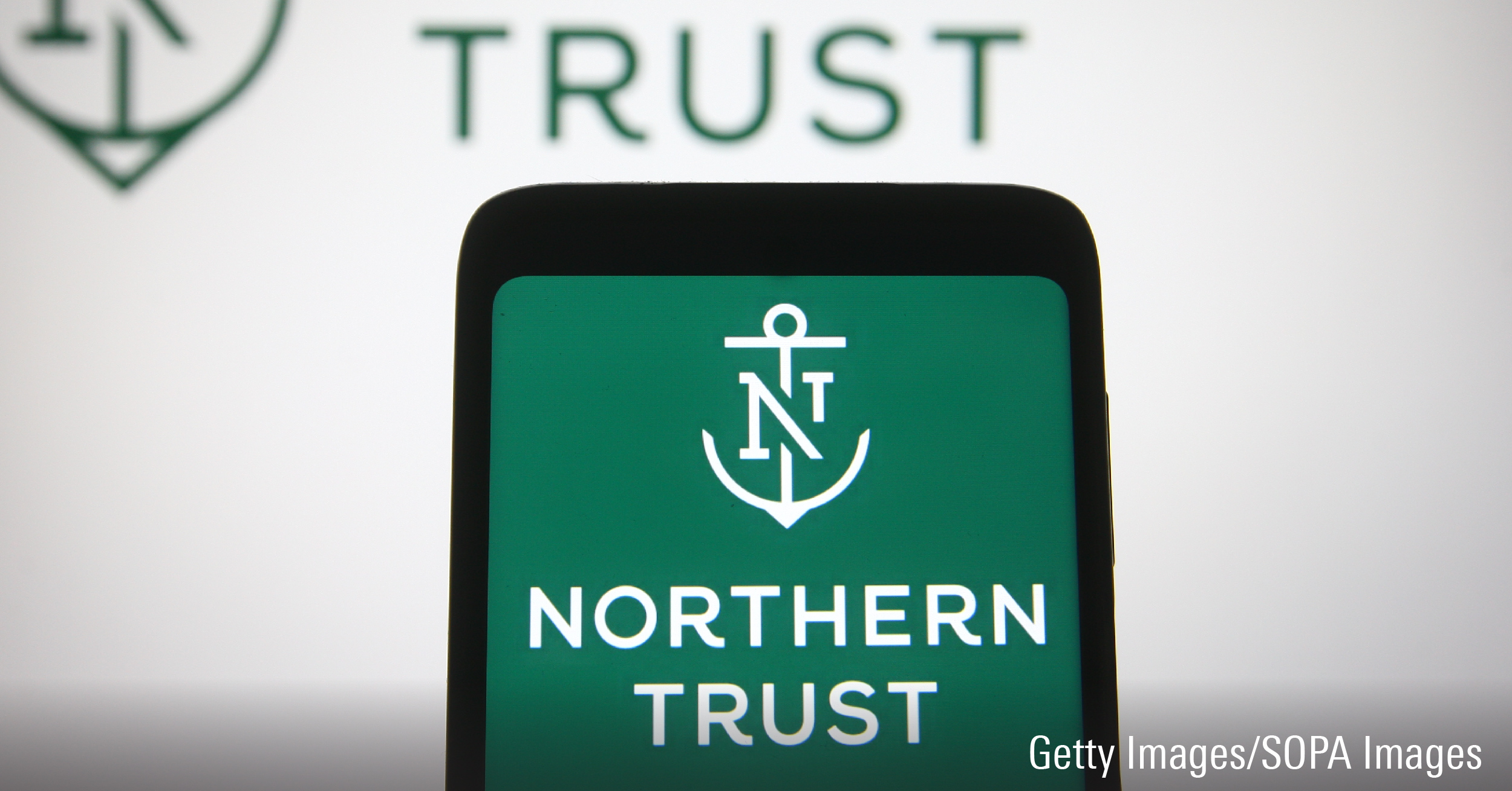 In this photo illustration the Northern Trust of a financial services company is seen on a smartphone.