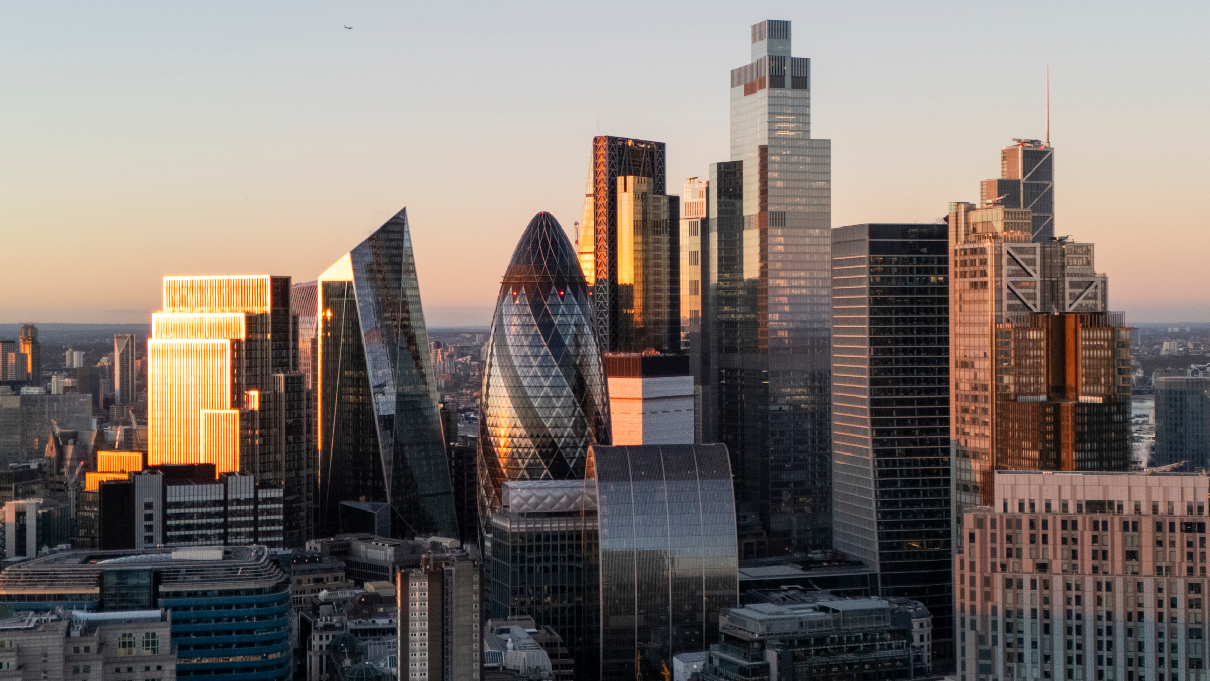 An aerial view of the London skyline at sunrise.