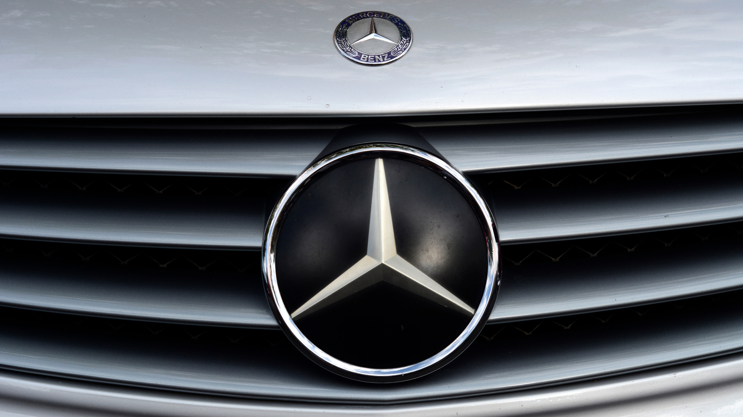 Das Mercedes-Benz-Logo auf dem Kühlerhaubenemblem und dem Kühlergrill eines Mercedes-Benz-Oldtimers.
