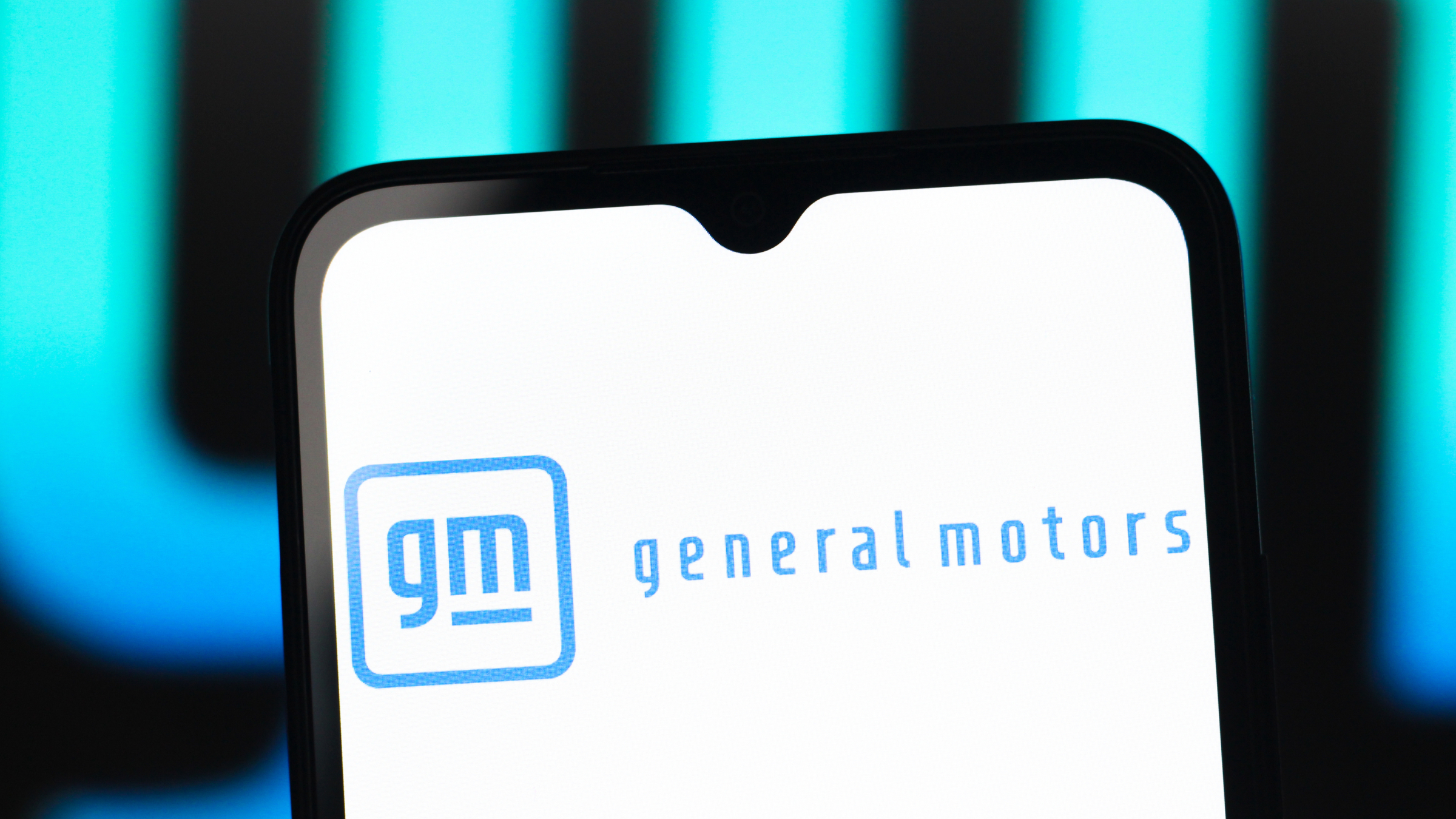 The General Motors Company (GM) logo is seen displayed on a smartphone screen.