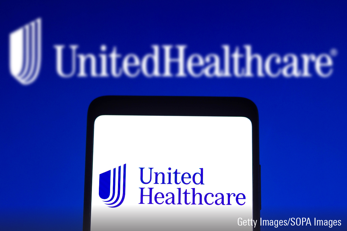 In this photo illustration, the UnitedHealthcare logo seen displayed on a smartphone screen and in the background.