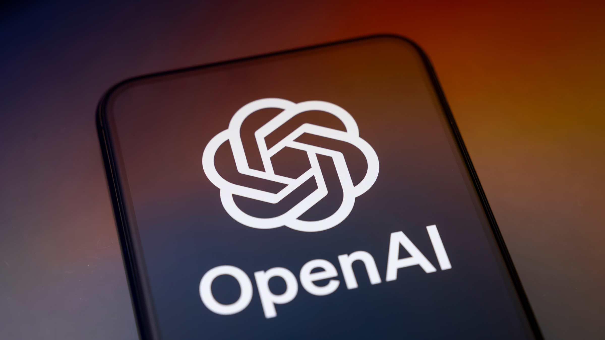 The Open AI logo is displayed on a smartphone screen.