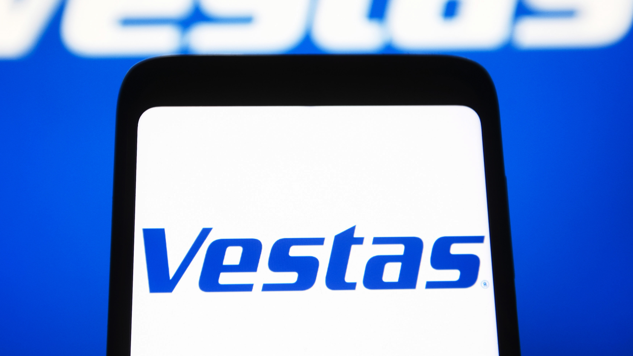 Vestas Wind Systems A/S logo is seen displayed on a smartphone and a pc screen.