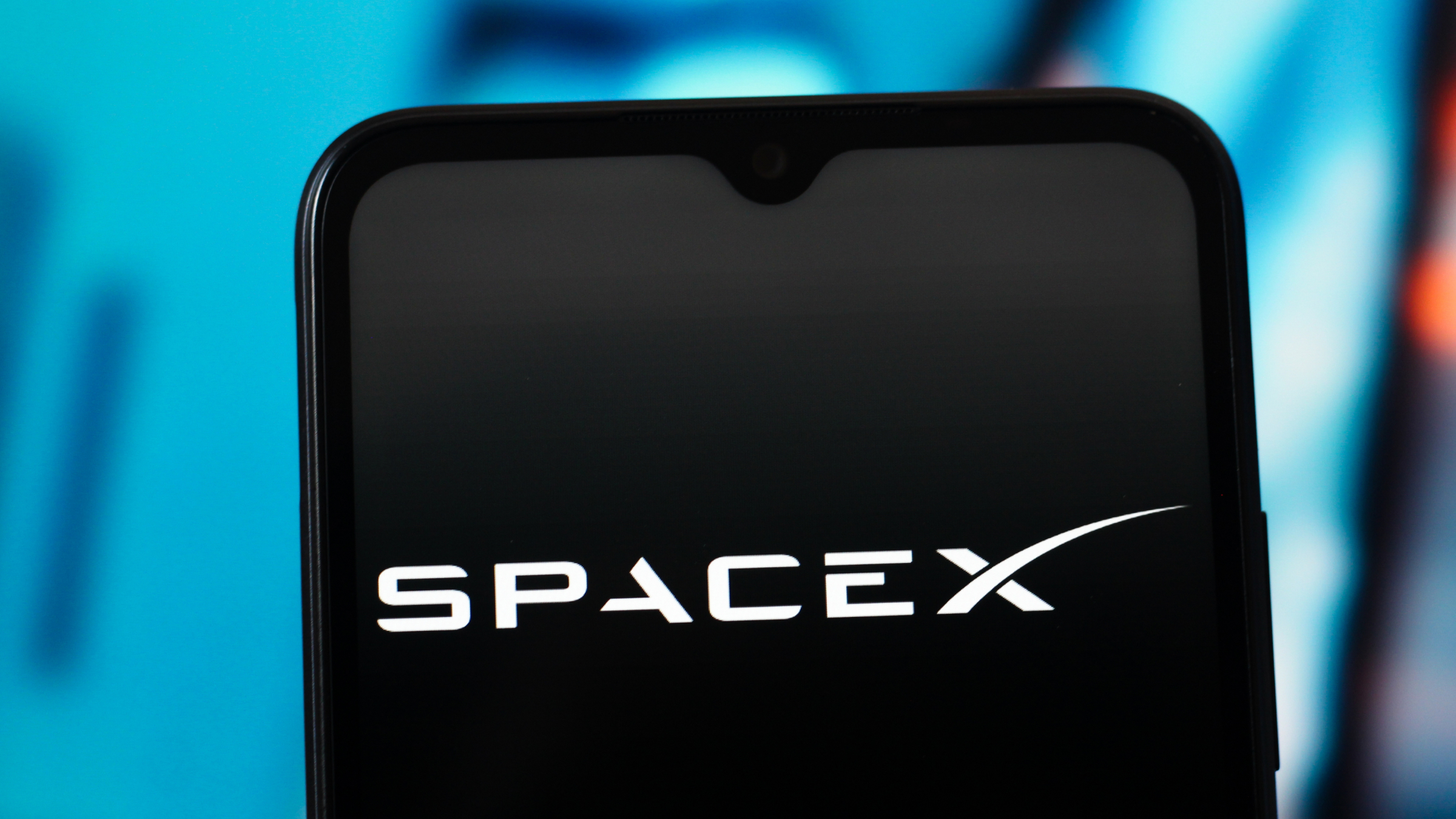 The SpaceX logo is seen displayed on a smartphone screen.