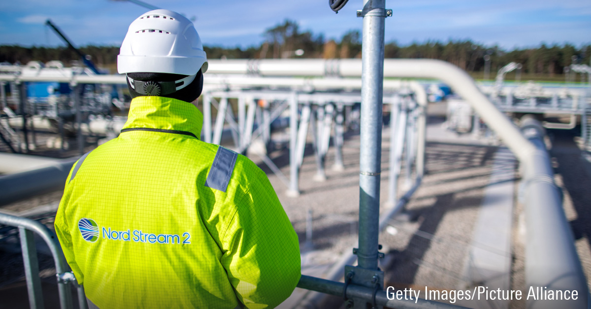 A photo depicting a Nord Stream employee overseeing a system of pipelines.