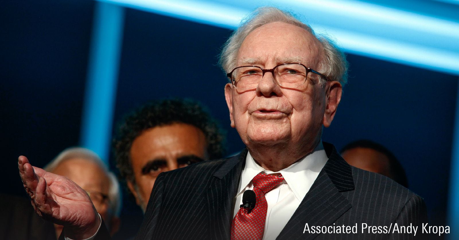 A photograph featuring Warren Buffet speaking at an event.