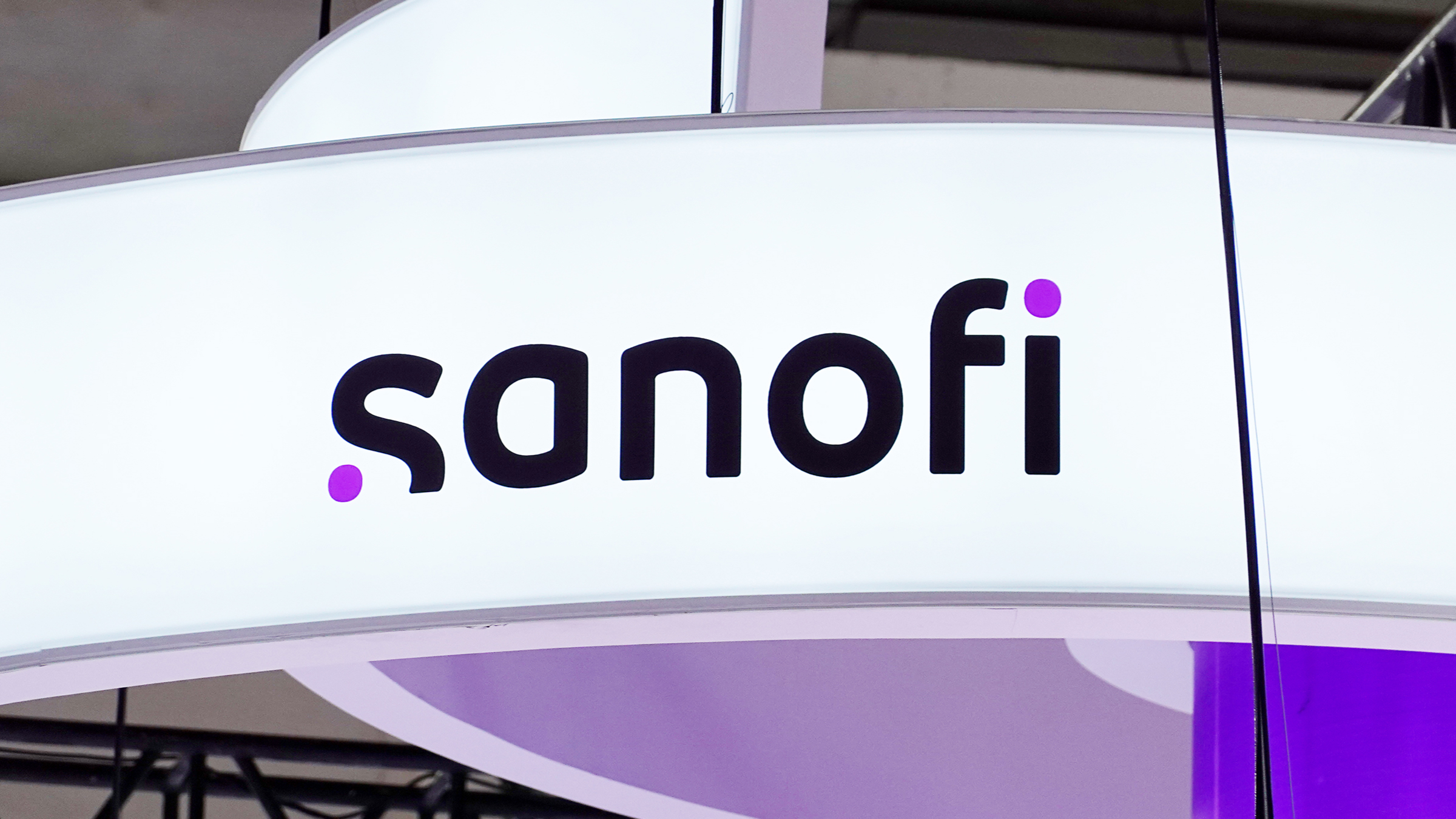 A close-up of the Sanofi logo on a curved white display