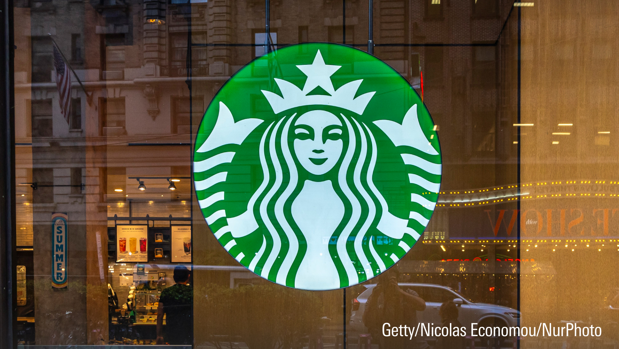 A store front of a Starbucks Coffee shop with people served inside.