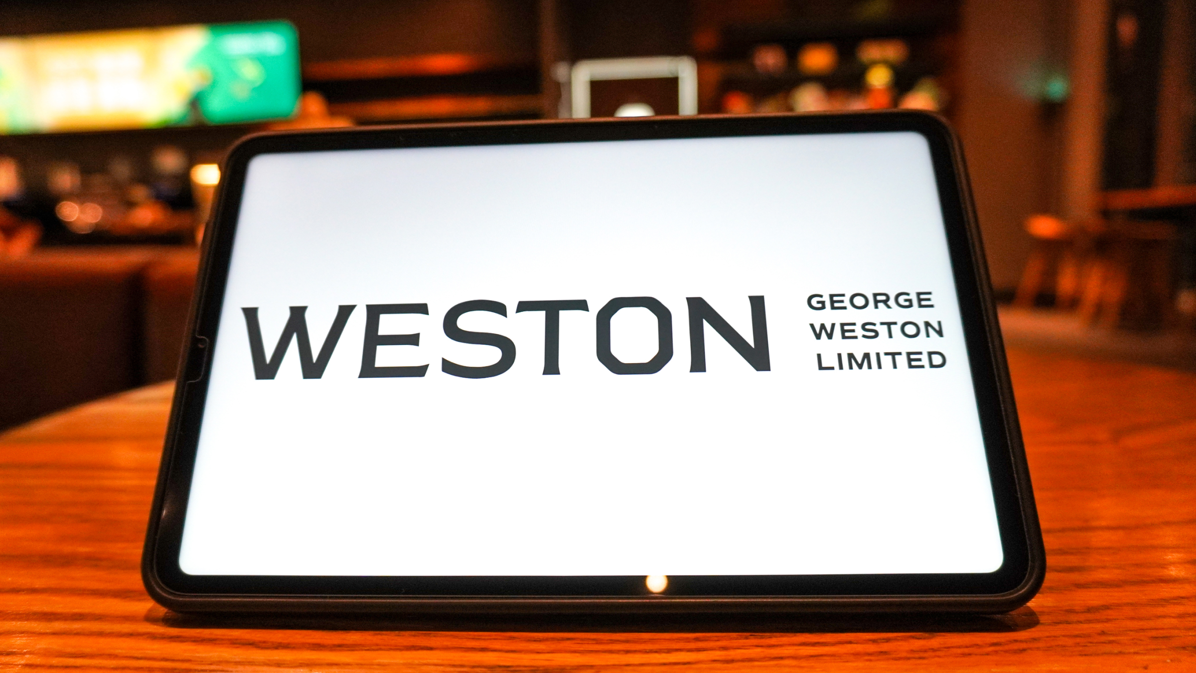 A George Weston Limited logo is displayed on the screen of a tablet.