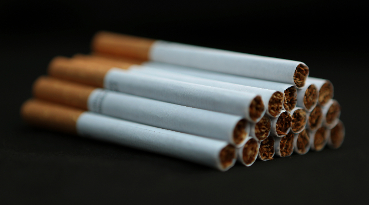 A picture of a neatly-stacked pile of cigarettes against a black background, illustrating so-called &quot;sin stocks&quot; ahead of the UK Budget 2024