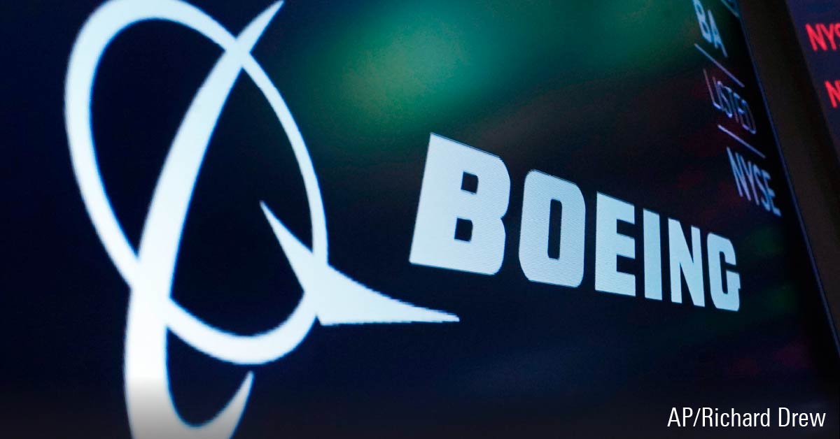 The logo for Boeing appears on a screen above a trading post on the floor of the New York Stock Exchange
