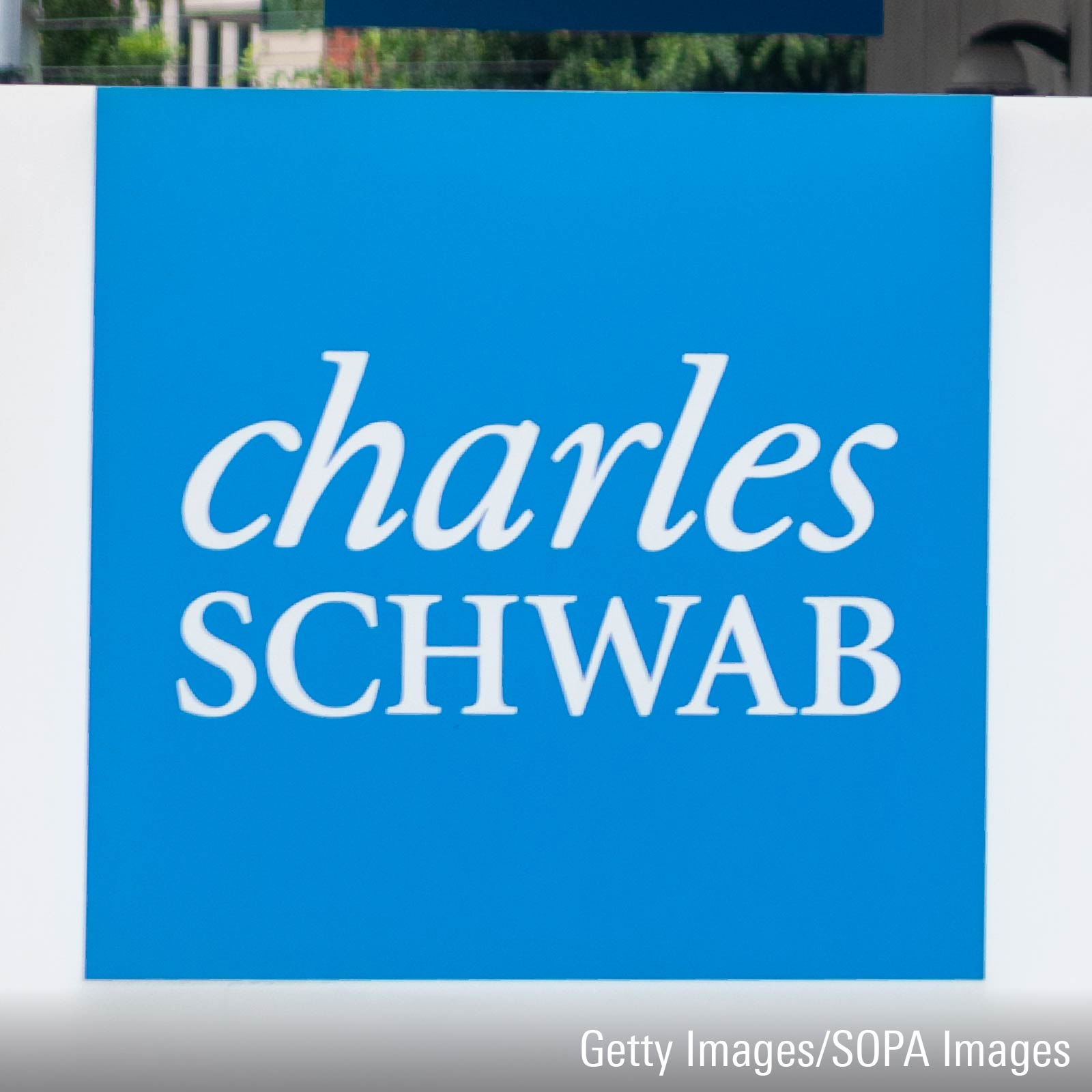 Charles Schwab logo in full color on large sign placed outside of San Francisco office building.