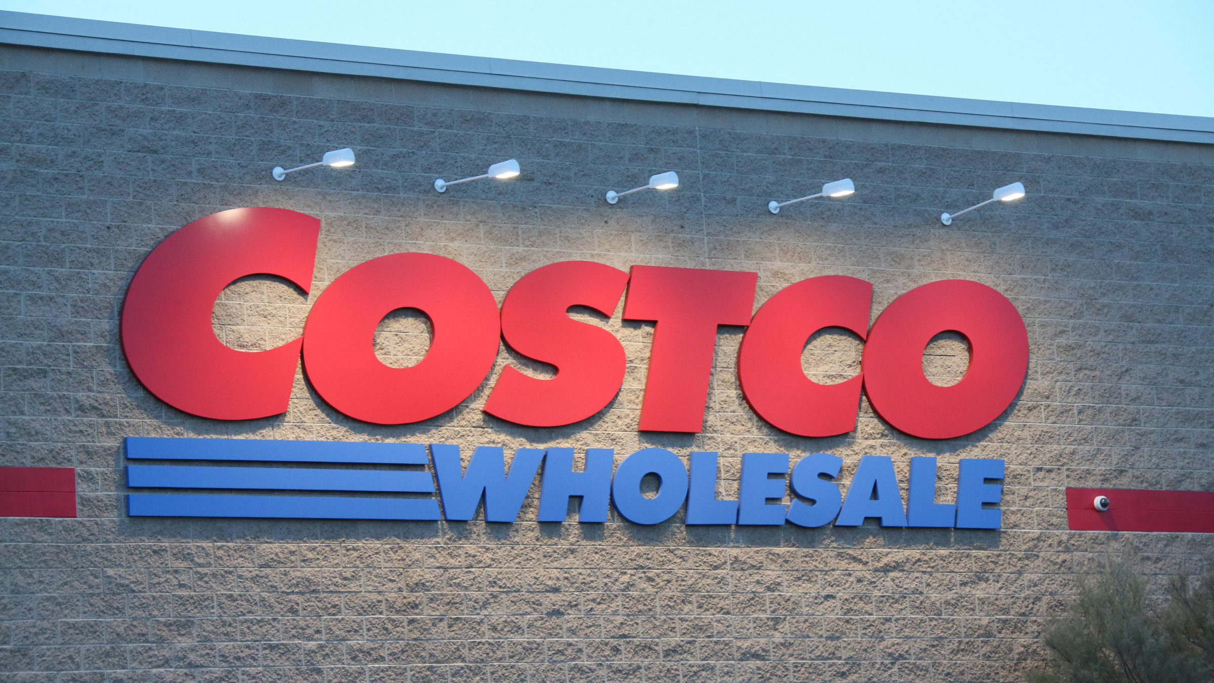 A Costco Wholesale Corporation logo is seen displayed on the exterior of their warehouse.