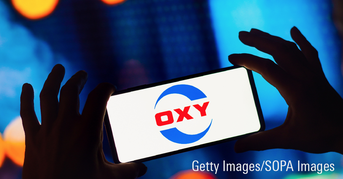 Person holding phone showing Occidental Petroleum logo.