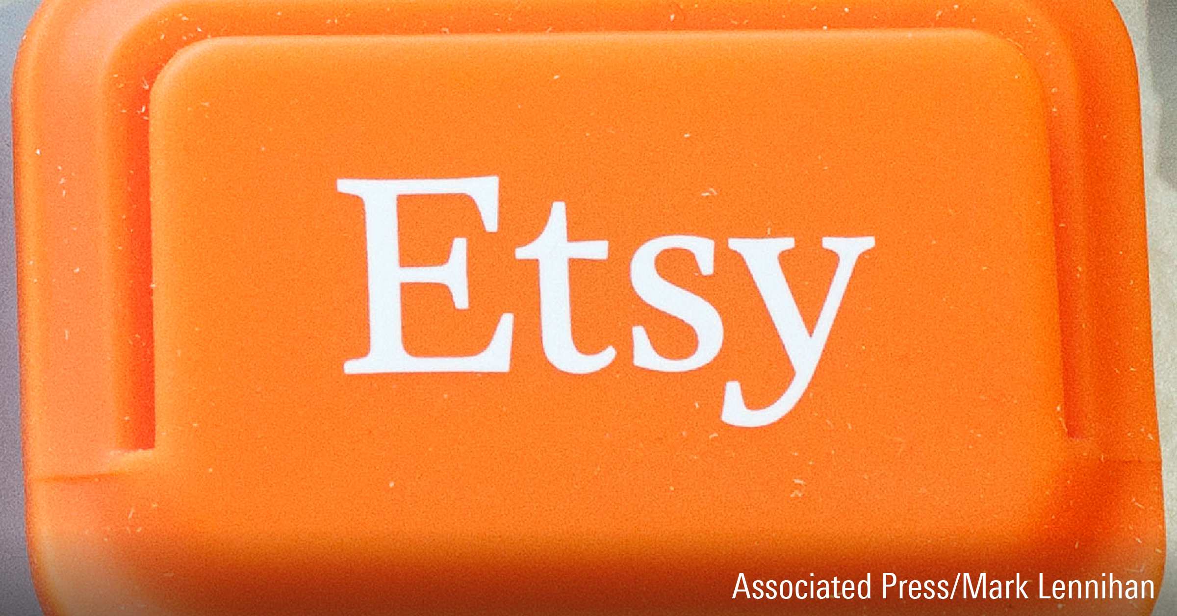 Etsy logo is shown on an Etsy mobile credit card reader.