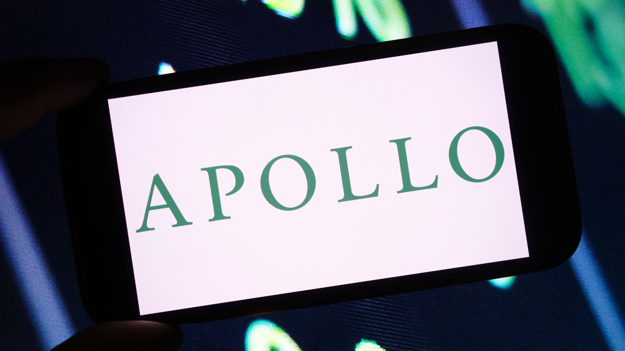 Thee Apollo Global Management company logo is seen displayed on a smartphone screen.
