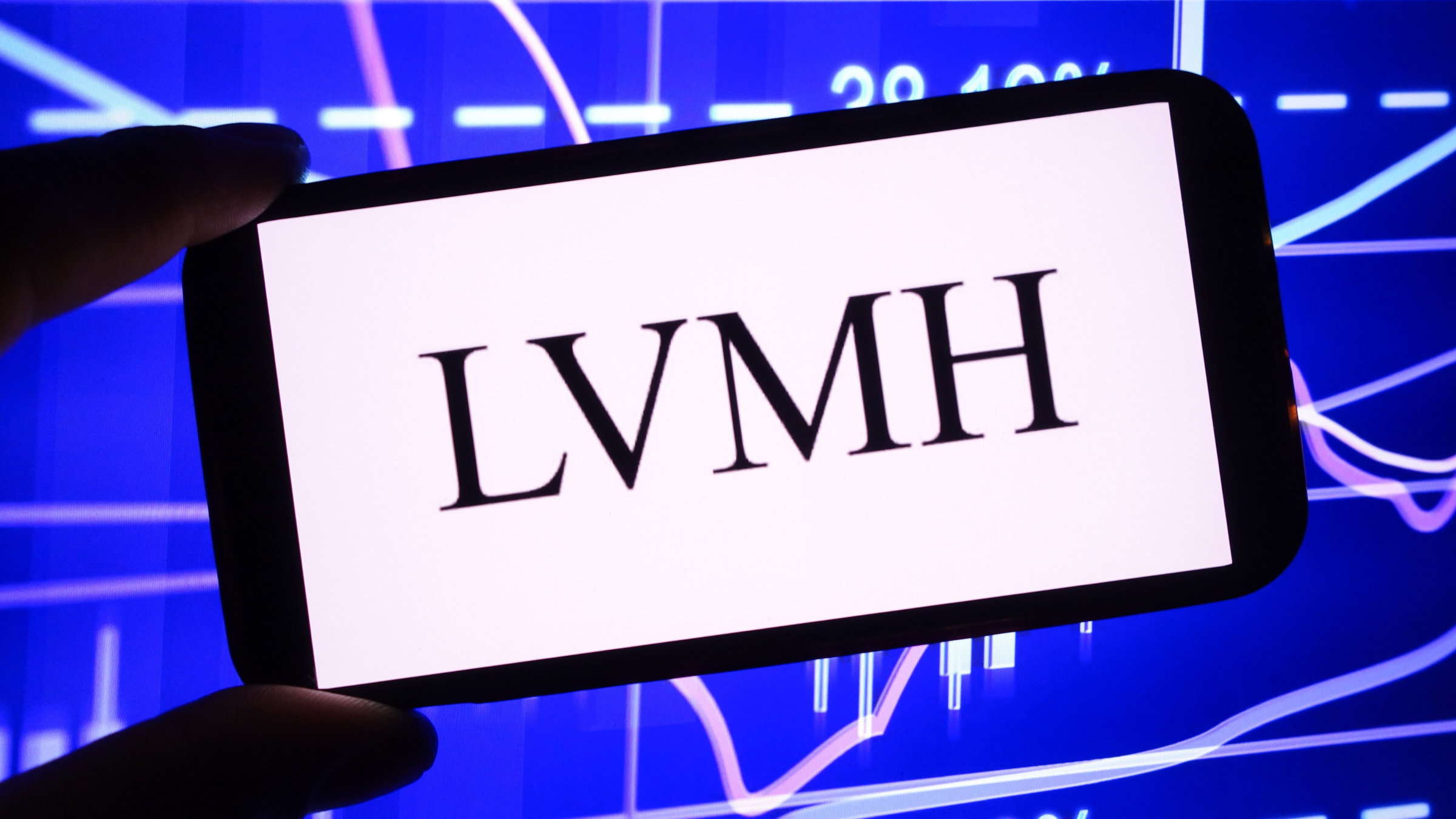 The LVMH logo is seen displayed on a smartphone screen.