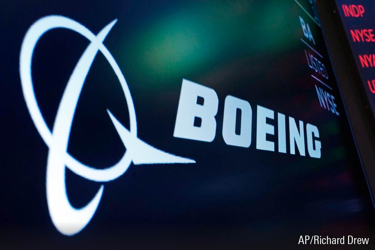 The logo for Boeing appears on a screen above a trading post on the floor of the New York Stock Exchange