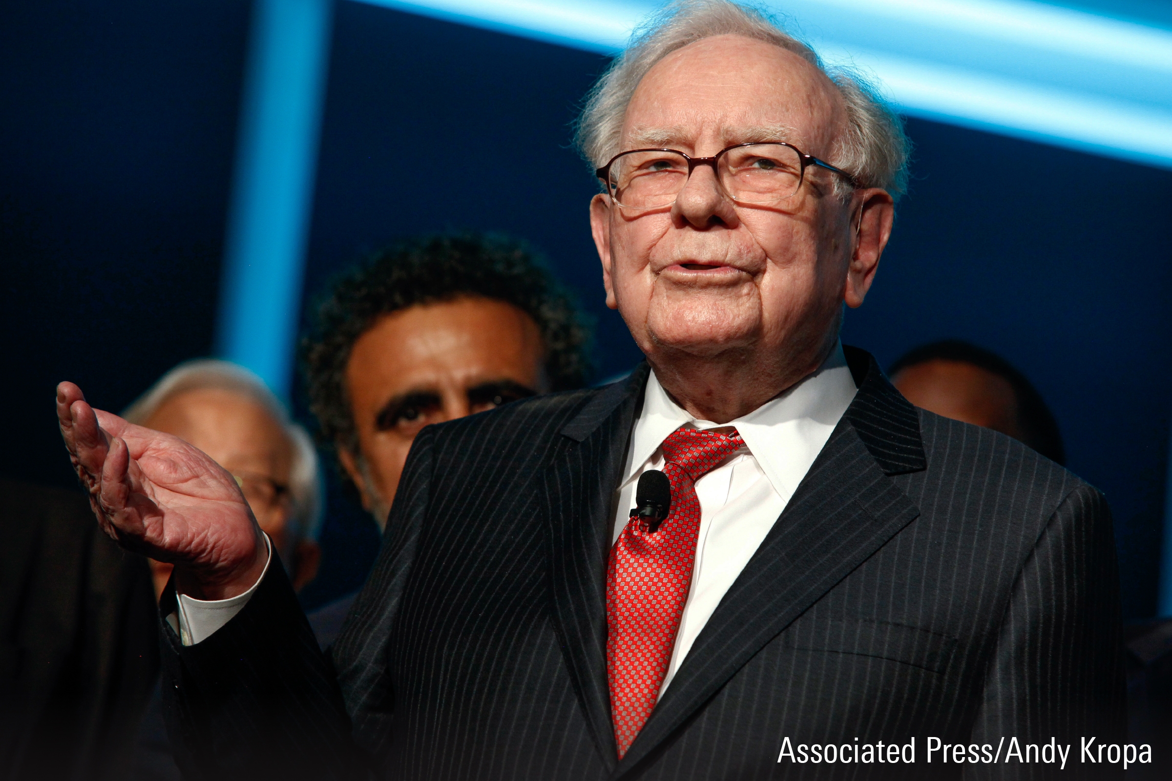 A photograph featuring Warren Buffet speaking at an event.