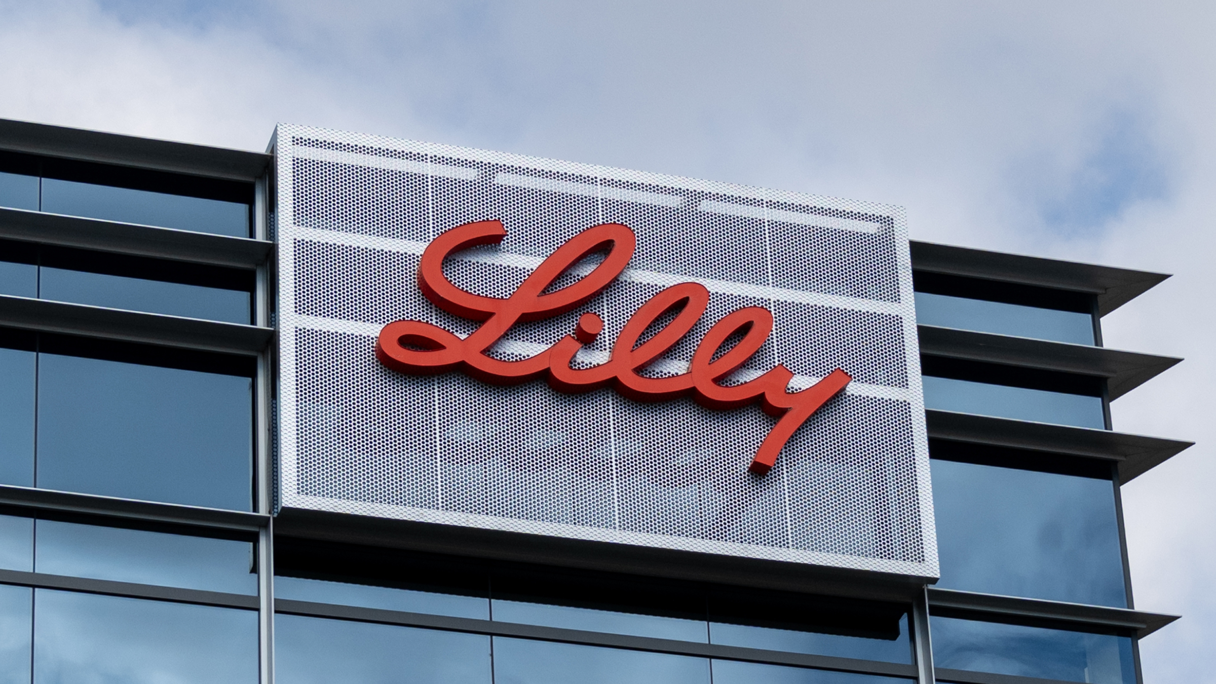 Eli Lilly logo on modern glass office building facade.