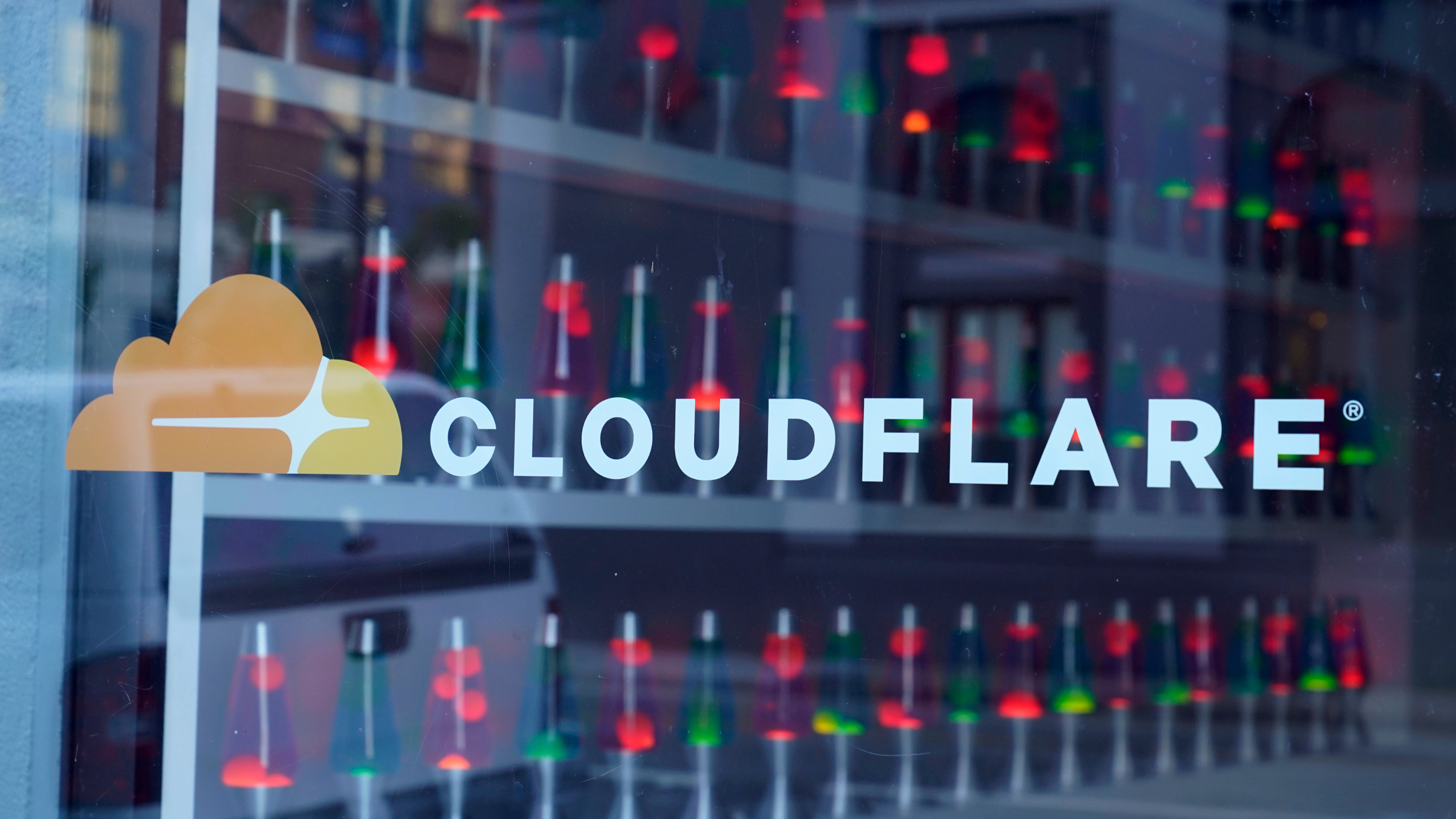 The Cloudflare logo on a glass panel.