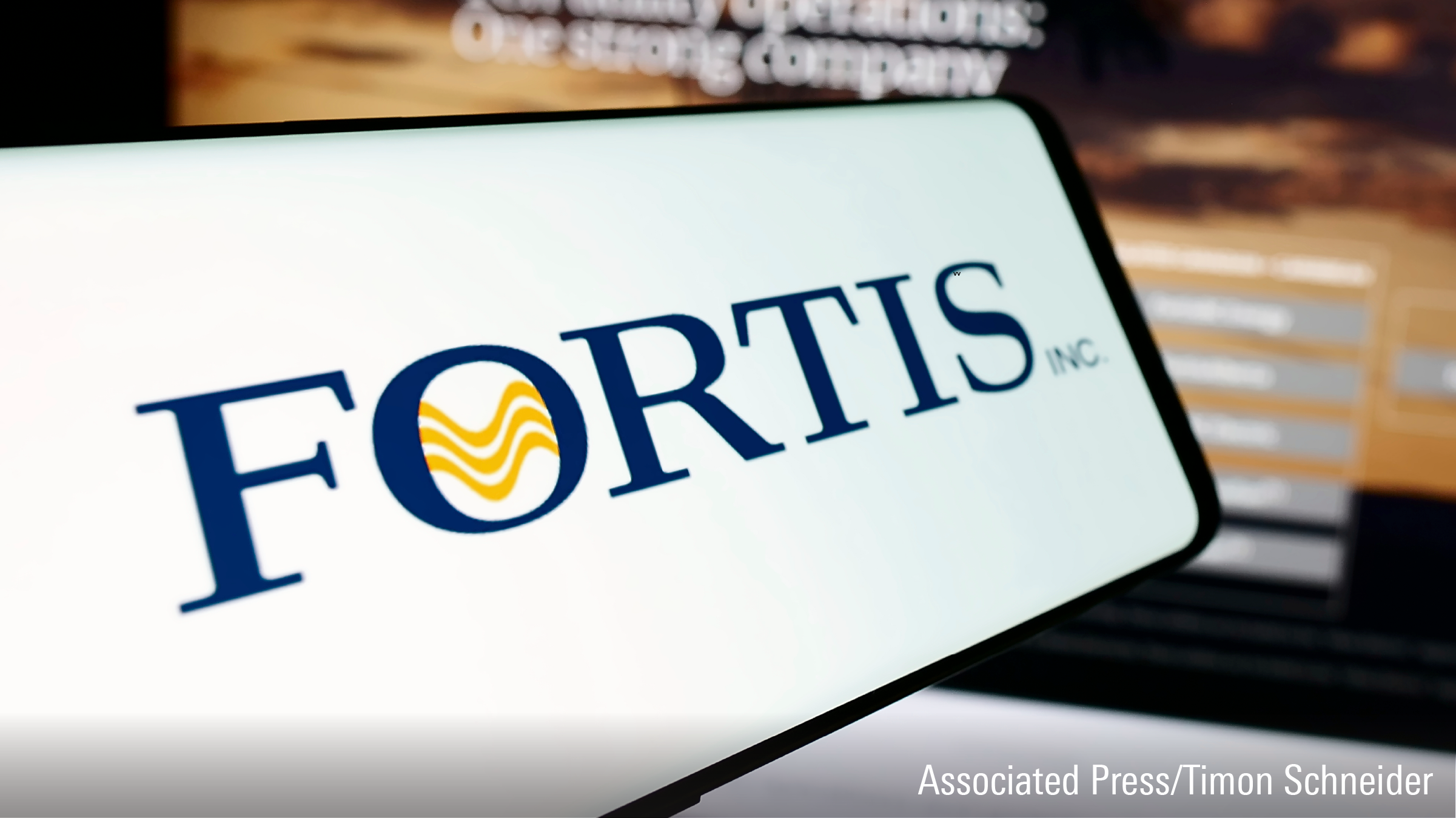 In this photo illustration, a smartphone with the logo of Canadian electric utility company Fortis Inc. is seen in front of business website.